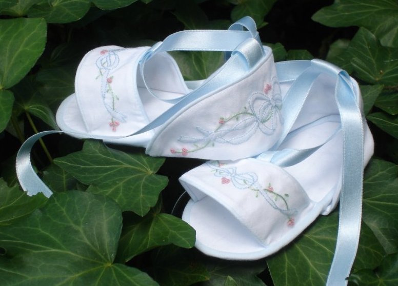 A pair of baby sandals with shadow work and embroidery